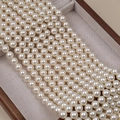 Lustrous creamy white glass pearl beads neatly arranged on a gray linen jewelry tray - 4mm Straight Hole/Approx 100pcs Per Strand / Color 650