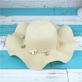 Dettaglio di cappello in paglia crema con tesa ondulata e decorazioni floreali - Adulto M / Beige