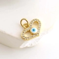 Macro shot of gold-plated heart pendant with zircon and blue evil eye detail - Micro Pave Heart Eye