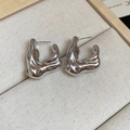 Macro shot of silver irregular lava earrings with organic shape and high-mirror finish - Silver V-Shape With Steel Pin