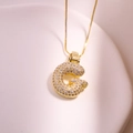 Détail macro du collier pendentif lettre G en or avec zircons micro-pavés sur plateau - Lettre G