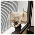 Close-up of white crocodile pattern leather handbag with gold U-shaped buckle and knot strap - White