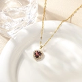 Close-up of heart-shaped ruby necklace with micro-pave diamond halo on white porcelain - Medium Purple Pendant Necklace