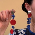 Dettaglio di orecchini con velluto rosso e perline corallo su mano e modella - Orecchini Con Perline Blu e Piastra Rossa Argento
