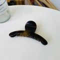 Detail of elegant amber tortoiseshell curved hair claw clip on a white tabletop surface - Matte Light Tortoise