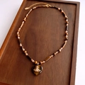 Detailed shot of tiger eye beaded necklace with heart pendant and Saturn orb logo - 22# Coffee-Heart