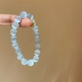 Detail view of light blue cat-eye beaded bracelet with a cute golden bear pendant charm - Gold Bear Pendant / 10mm / White