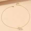 Collana a cerchio ritorto dorato con zirconi su sfondo beige minimalista - Collana dorata con pavé