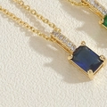 Macro shot of 14K gold plated necklace with blue rectangular zircon and pavé crystal bail - Sapphire Blue
