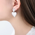 Eleganti orecchini a doppio cuore in argento indossati da una modella in primo piano - Orecchini / Color Acciaio