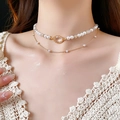Detailed view of layered pearl necklace with champagne gem pendant on model's neck - Gold