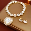 Dettaglio del set con collana a cuore e orecchini di cristallo su espositore - Stile Cuore Trasparente (HN5663) / Oro Trasparente
