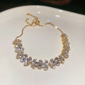 Gold adjustable bracelet with marquise-cut green zircon flowers in ceramic tray - White