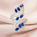 Makroaufnahme eines Silberrings mit blauen Edelsteinen und Pavé auf rosa Seide - US 7 / Blau
