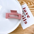 Matte dusty pink rectangular hollow hair claw clip for women on a ceramic plate - Pink
