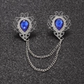 Close-up of vintage silver brooches with blue teardrop gems and double metal chains - White Gold Plated Royal Blue N-149