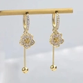 Elegante goldene Blumenohrringe mit Quasten und Kristallen auf einem Schmuckständer - Goldener Blumenquasten-Stil (AC-7311)