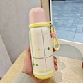 Close-up detail of insulated water bottle with cute grid pattern and convenient silicone strap. - 500ml / Pink-Yellow Grid Style (BWB6114)