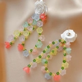 Pendientes de flores acrílicas de colores con agujas de plata sobre fondo de raso beige - Flores de colores (HE7761)