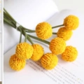 Künstlicher gelber Trommelstock-Blumenstrauß auf offenem Buch für nordisches Dekor - Orange