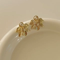 Golden leaf stud earrings with white pearl detail hanging on a ceramic dish - Gold Leaf Pearl