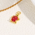 Detail of 18k gold turtle pendant featuring a red oval zircon stone and top ring loop - Red (Turtle Style A)