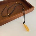 Detailansicht eines goldenen Erdnussanhängers mit matter Textur an einer schwarzen Kette - Erdnuss Schote Anhänger / Gold