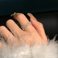 Elegant silver criss-cross ring with sparkling stones worn on a finger with manicured nails - JZ0185 (Cross Pave)