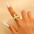Detailed shot of golden four-petal flower ring with pink center stone on hand - Gold (5784)