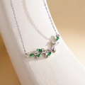 Silver antler necklace with green and clear gemstones on a white textured display - XL1994 Branch Leaf Deer Horn Silver