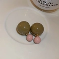 Gros plan de boucles d'oreilles double perle vert olive et rose sur un plateau en céramique - Café (Tige de boucle d'oreille en argent)