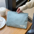 Macro-opname van lichtblauwe corduroy make-up tas textuur met een klein geweven label - Lichtblauw Grijs