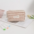 Detail view of brown waffle fabric cosmetic bag with meyou fairy label on magazines - Beige