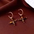 Detail of 18K gold plated tiger eye flower earrings on dark brown silk fabric background - Gold Plated Tiger's Eye Gold