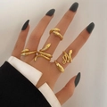 Detail shot of five gold-tone snake-shaped rings with green eye accents on hands - Coiled Snake Gold 5-Piece Set (5540101)