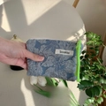 Detail of blue embossed floral tissue makeup pouch with green woven zipper puller - Bubble Big Flower Grey Blue
