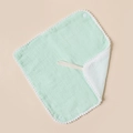 Detail of baby muslin bib with white pom-pom trim and snap buttons in mint green - Emerald And White