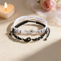 Matching Yin Yang braided rope bracelets for couples with magnetic charms in a romantic setting - Black & White Tai Chi Braided Rope Set