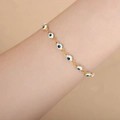 Gold evil eye bracelet with white and blue enamel beads on woman's wrist - White Green Enamel Gold Bracelet / 18+4CM