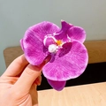 Detail of purple orchid hair clip with white pearl center for elegant hairstyling - Purple