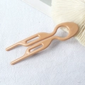 Detailed view of a minimalist U-shaped hair fork in beige on a textured white fabric background - 9cm Fishtail Double Prong (Nude) / 9cm U-Shaped Hair Fork / Nude