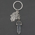 Hexagonal crystal pillar keychain with silver Hamsa hand charm on a dark background - White Crystal