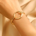 Close-up of golden hammered alloy bracelet with circular design on champagne silk - Gold Round Hammered (1130)