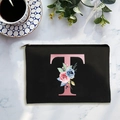 Black canvas cosmetic bag featuring a floral letter T print with smooth zipper closure - Letter T