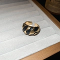 Dettaglio dell'anello regolabile con smalto nero e oro dal design a onde moderne - Aperto Regolabile / Nero