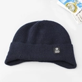 Macro shot of navy blue ribbed knit beanie with folded cuff and star logo patch - Earflap Style / Navy Blue