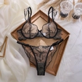 Detailansicht eines schwarzen Sets aus Spitzen-BH und String mit feiner Stickerei - S / Schwarz