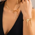 Nahaufnahme des goldenen Schleifen-Schmucksets mit flacher Schlangenkette an einem Model - Schleife Schmuckset (Halskette Und Armband) (4818) / Gold Set Stil 5