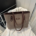 Bolso tote vintage de pata de gallo con asas de cuero marrón sobre una chaqueta blanca - Marrón