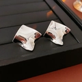 Close-up of silver-tone twisted square stud earrings on a black jewelry tray display - Silver Pin Silver / Silver